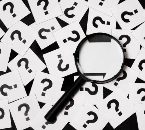 Photo de points d'interrogation et d'une loupe