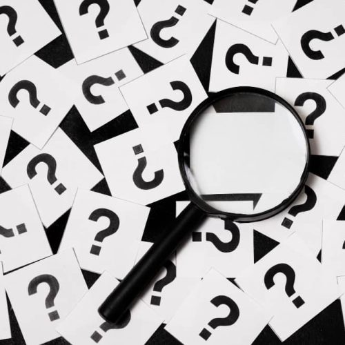 Photo de points d'interrogation et d'une loupe